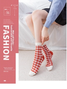 Red and white checkered crew socks made of combed cotton worn by a model in a cozy setting