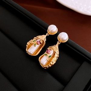 Detail of gold baroque earrings with imitation pearls and enamel floral inserts