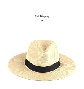 Detail view of woven texture and black ribbon band on a beige straw Panama hat