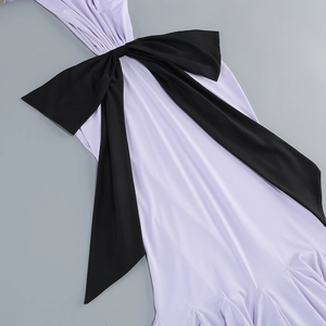 Detail of lavender dress featuring a large black decorative bow and smooth fabric