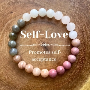Macro shot of 8mm natural stone beaded bracelet on wood with self-love text overlay