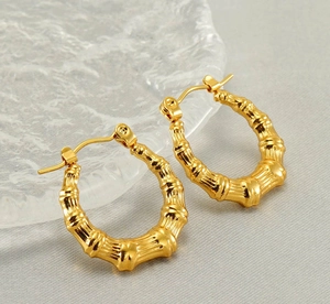 Dettaglio ravvicinato di orecchini a cerchio texture bambù in acciaio inossidabile 18K