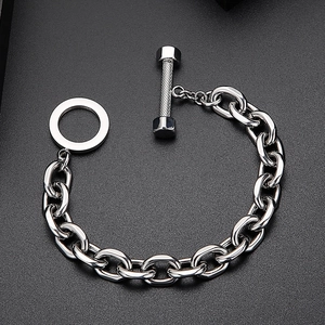 Polished stainless steel industrial chain bracelet with dumbbell toggle clasp on gray sand