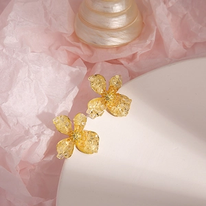 Detail of yellow floral stud earrings with crystal texture and golden pistil details
