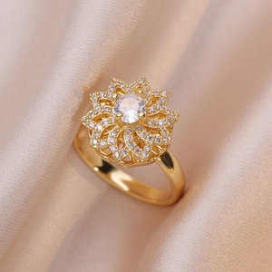 Elegante anello a fiore dorato con micro-pavé di zirconi su raso color champagne
