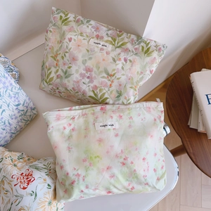 Détail de trousses à maquillage en coton fleuri avec étiquette Simple Wish
