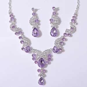 Macro detail of lavender crystal drop earrings and necklace set on silver metal