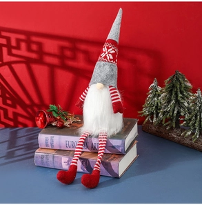 Close-up of Nordic Christmas gnome doll with long striped legs sitting on books