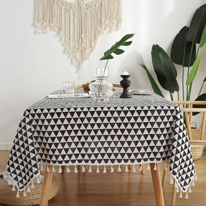 Detail of cotton linen tablecloth with black and white geometric patterns and tassel trim