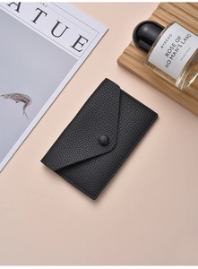 Close-up of black litchi pattern leather wallet with snap button and envelope design