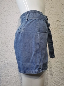 Dettaglio di pantaloncini di jeans a vita alta blu scuro con cintura e tasche laterali