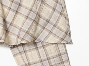 Detail of beige and brown checkered fabric with natural linen texture and fine stitching