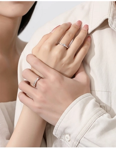 Close-up of elegant S925 silver couple rings with wave design on hands