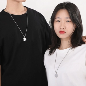 Couples stainless steel puzzle piece necklaces worn by male and female models