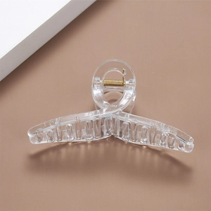 Close-up of a large transparent square hair claw clip with golden metal spring detail