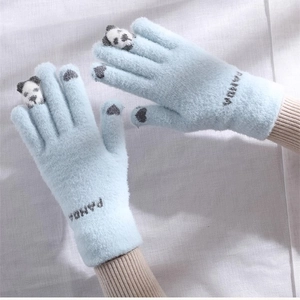 Detail view of cute winter warm knitted gloves with panda fingertip design and soft texture.