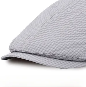 Detailed view of light grey beret cap featuring breathable textured grid fabric texture