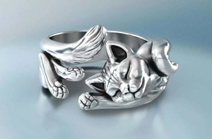 Close-up detail of silver cat ring showing intricate carved fur texture and sleeping posture