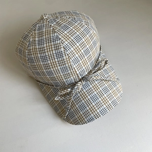 Détail d'une casquette de baseball à carreaux fins avec nœud et texture de tissu respirant