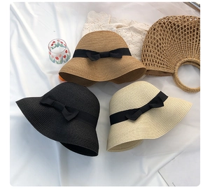 Three elegant straw sun hats in black, beige and natural with chic black ribbon bows