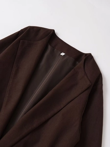Detailopname van de donkerbruine blazer kraag en voering met het label maat S