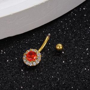 Macro view of golden belly button ring with orange gem and sparkling rhinestones