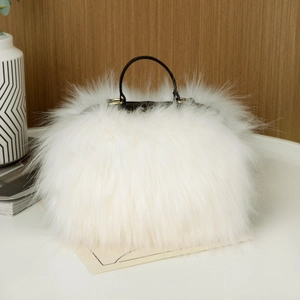 Detail view of white faux raccoon fur handbag with black handle and gold hardware buckles