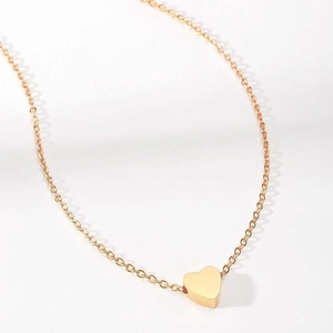 Macro view showing the polished gold heart pendant and fine chain of the necklace