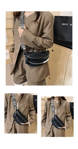 Detail of black crescent chest bag with pearl chain and textured pleated fabric