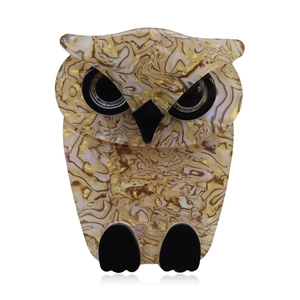 Cartoon owl brooch in beige acrylic with faux tortoiseshell texture on white background