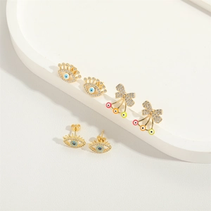 Gold bow cherry and eye earrings set with colorful zircons on white tray