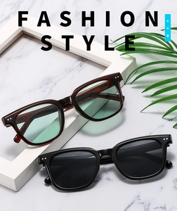 Detail of square vintage sunglasses with silver rivet accents on marble background