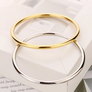 Nahaufnahme von minimalistischen Armreifen aus Edelstahl in Gold- und Silberoptik