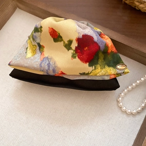 Close-up of floral fabric scrunchie with yellow flower pattern and gold Love tag