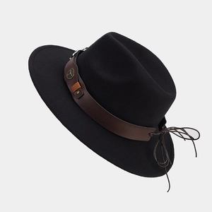 Détail d'un chapeau fedora noir avec ruban en cuir marron et boucle en métal à tête de taureau