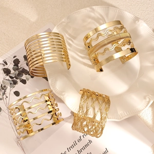 Élégant ensemble de bracelets manchettes dorés en spirale sur assiette céramique