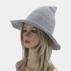 Close-up of light gray knitted witch hat with pointed top and wide brim for Halloween