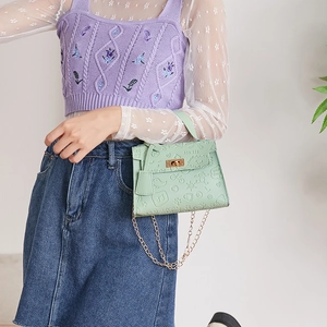 Close-up of mint green Kelly bag featuring cartoon embossed patterns and gold chain