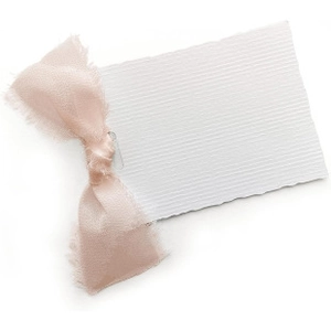 Detailansicht eines weißen Geschenkanhängers mit elegantem rosa Chiffonband und Fransen