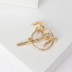 Golden gymnast gymnast brooch in circular frame on minimalist white geometric display