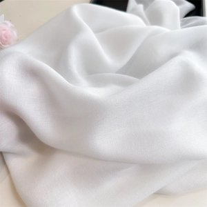 Close-up of white cotton linen fabric showing soft texture and delicate natural luster