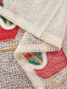 Close-up of Santa Claus embroidery and red heart patterns on lace Christmas tablecloth