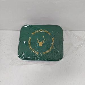 Top view of green Christmas tin box with golden deer head and Merry Christmas text