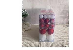 Détail de boules de Noël rouges et blanches dans une boîte cadeau transparente