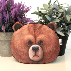 Detail of 3D realistic brown bear plush coin purse with zipper and side label on a white table