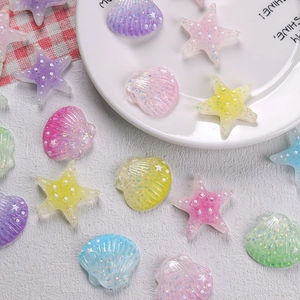 Close-up of colorful glitter resin starfish and seashell charms for DIY hair clips
