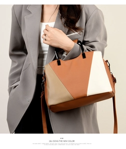 Detail of color-block tote with acrylic handle and adjustable strap on a gray blazer