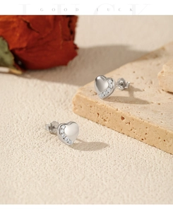 Macro shot of S925 sterling silver heart earrings with half-pave cubic zirconia on stone