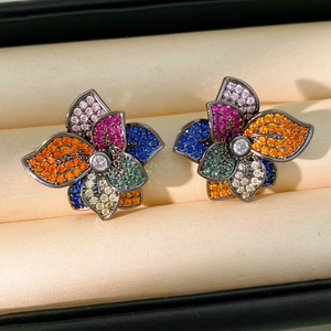 Close-up of vintage flower stud earrings featuring colorful zircons and dark gold finish