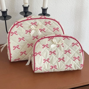 Detailed macro of the quilted texture and sweet pink bow patterns on the cosmetic bag set